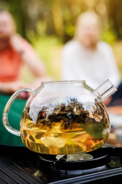 Şeffaf bir çaydanlık elektrikli bir ocakta ısıtılır. Çay kaynıyor.