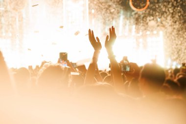 İnsanların ellerinin silueti müzikal konserde yükseldi, müzikten, dans kulübünden keyif aldı.