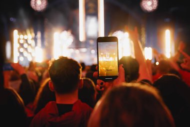 Bir müzik konserinde cep telefonuyla fotoğraf ya da video içeriği çekmek