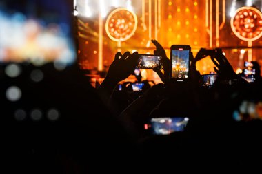 Bir konser sırasında cep telefonuyla dans pistinden yayın yapmak..