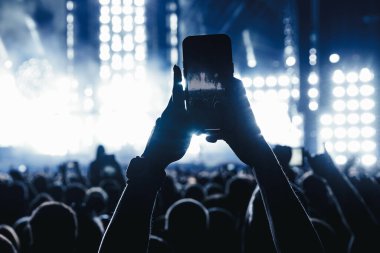 Bir müzik konserinde cep telefonuyla fotoğraf ya da video içeriği çekmek