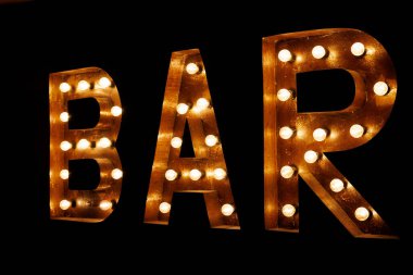 Bar tabelası. Parlayan ampullerle süslenmiş büyük metal harflerin yazıtları.