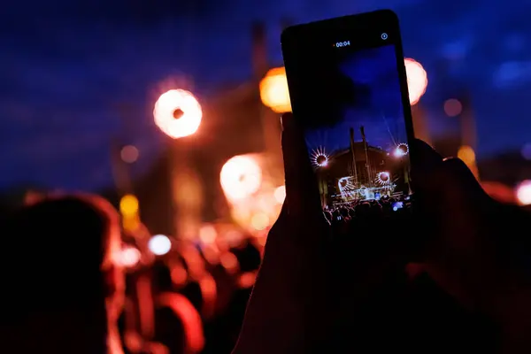 Taking a photo or video content at a music concert using a cell phone