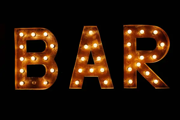 Luminous letters BAR. Volumetric letters from rusty metal with a garland of incandescent lamps