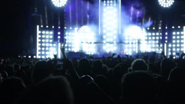 Mutlu insanlar bir konser sırasında dans pistinde ellerini kaldırarak kalabalıklar.