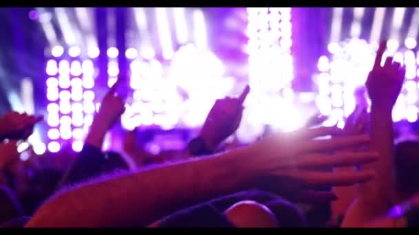人们在音乐会上挥手挥手挥手 后台明亮的舞台灯光和烟火 — 图库视频影像