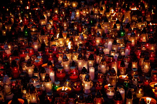 Many colorful lit memory candles in the dark. A beautiful display of colorful candles glowing in the night.
