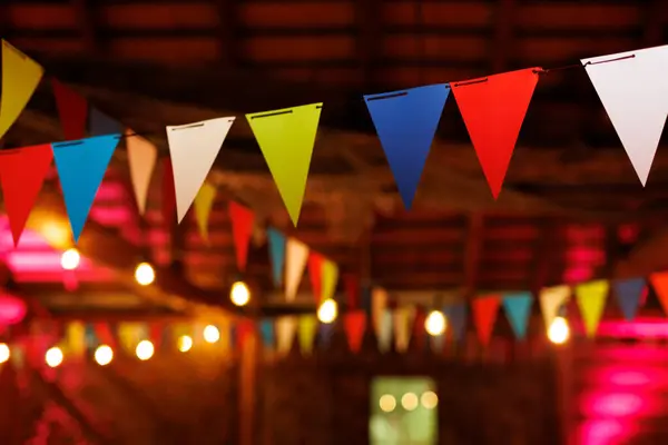 Festive party venue decorated with colorful pennant banners and string lights.
