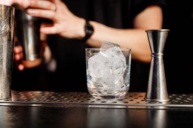 Alkollü kokteyl hazırlarken buzlu bardaklar.