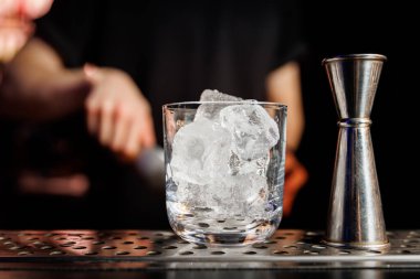 Alkollü kokteyl için buz. Barmen barda kokteyl hazırlıyor.