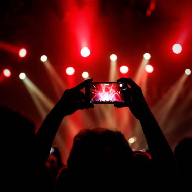 Anı sosyal ağlarda arkadaşlarla paylaşmak için konser sırasında akıllı telefonla fotoğraf çekmek