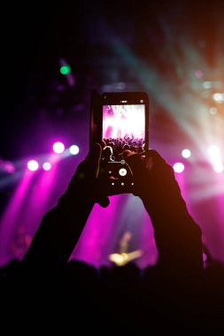 Bir telefon tutup konserin fotoğraflarını çekmek. Konser arkaplanı