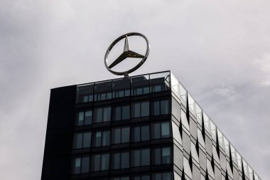 Berlin, Almanya - 1 Nisan 2024: Bir ofis binasının çatısında dönen Mercedes logosu