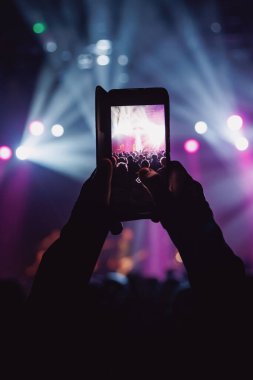 Sahnede bir konseri cep telefonu, müzik ve ışık gösterisiyle çekmek