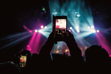 Akıllı telefon kamerasıyla canlı müzik konseri kaydeden biri.