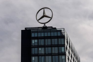Berlin, Almanya - 1 Nisan 2024: Bir ofis binasının çatısında dönen Mercedes logosu