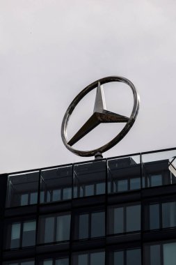 Berlin, Almanya - 1 Nisan 2024: Bir ofis binasının çatısında dönen Mercedes logosu