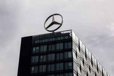 Berlin, Almanya - 1 Nisan 2024: Bir ofis binasının çatısında dönen Mercedes logosu