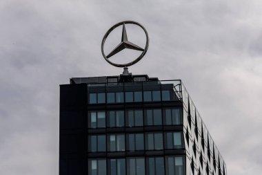Berlin, Almanya - 1 Nisan 2024: Bir ofis binasının çatısında dönen Mercedes logosu