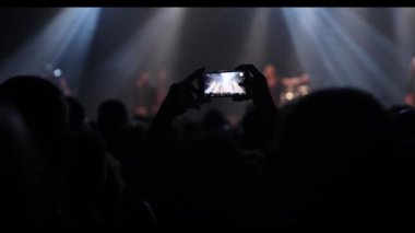 Streaming a music concert to social media via smartphone.
