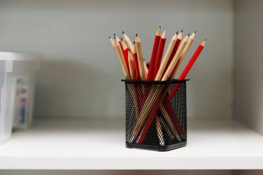 An array of classic wooden pencils stands at attention in a sleek desk organizer clipart