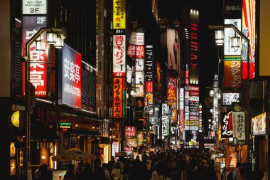 TOKYO, JAPONYAN - 22 Ekim 2024 Tokyo şehrinin enerjik gece hayatı kültürü, neon ışıklarıyla dolu hareketli bir şehir caddesi