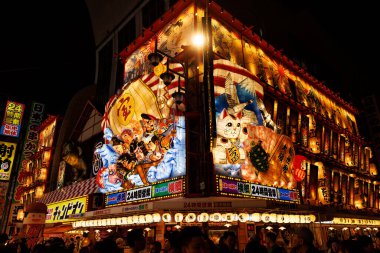 OSAKA, Japonya - 26 Ekim 2024: Renkli bir Japon caddesi Gece Canlı Binalar Cephesi.