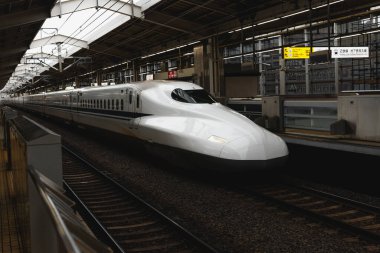 Yüksek hızlı Japon Shinkansen treni istasyonda yolcuları bekliyor.