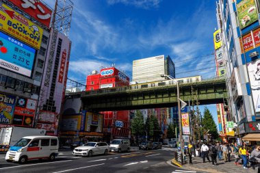 Tokyo, Japonya - 1 Kasım 2024: Tokyo 'daki Akihabara Bölgesi açık mavi gökyüzünün altında renkli reklam panoları ve hareketli etkinliklerle dolu