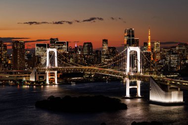 Metropolün üzerinde gün batımı. Tokyo siluetiyle Gökkuşağı Köprüsü