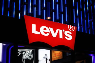 PARIS, FRANCE - 18 Şubat 2025: üzerinde Levi 's yazan büyük kırmızı bir tabela. İşaret yandı.