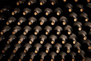 Eski tozlu şarap şişeleri mahzende birbiri üstüne bırakılır.