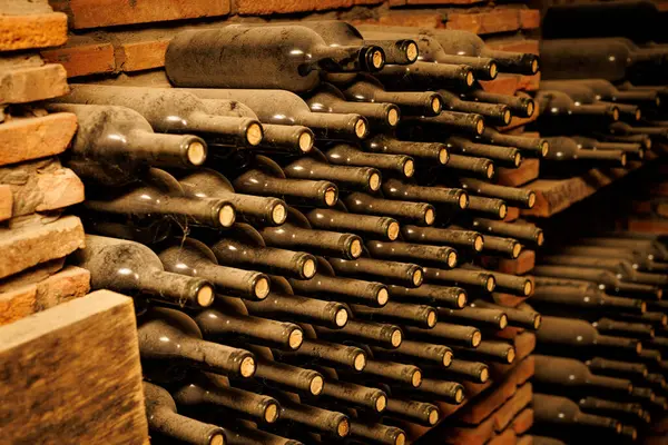 Bir sıra şarap şişesi üst üste yığılmış..