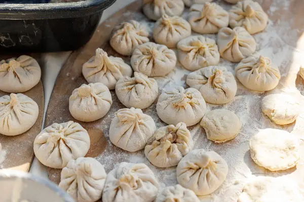 Büyük bir çörek yığını ahşap bir masanın üzerinde oturuyor. Çörekler tamamen farklı şekillerde.