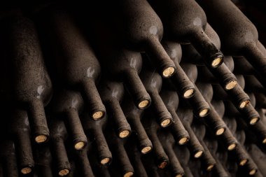 Eski tozlu şarap şişeleri mahzende birbiri üstüne bırakılır.