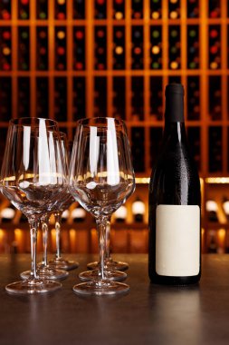 Masada dört şarap kadehinin yanında bir şişe şarap var. Sahne bir barda ya da restoranda geçiyor.