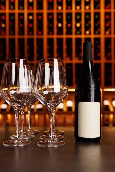 Masada dört şarap kadehinin yanında bir şişe şarap var. Sahne bir barda ya da restoranda geçiyor.