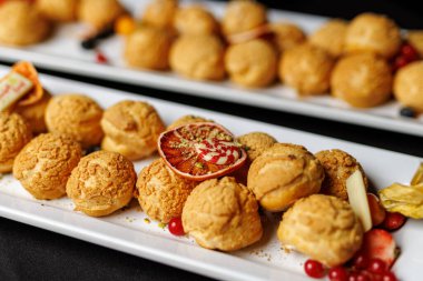 Üstünde kırmızı meyve olan bir tabak hamur işi..