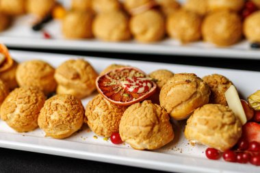 Garnitürlü beyaz tabakta kremalı puf kurabiyelerinin yakın çekimi.