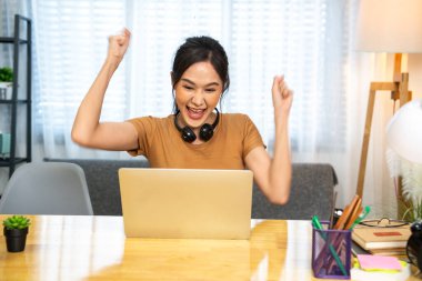 Asyalı kız öğrenci evde oturup ödevlerini yazıyor internetten öğretmenlere göndermek için evde klavye kullanarak eklem ağrısı ve yorgunluk hissediyor..