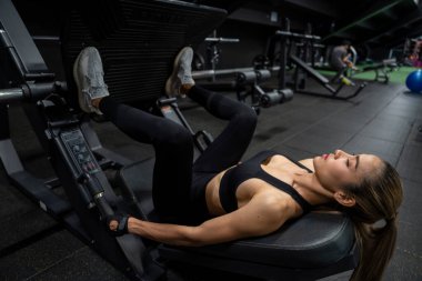 young beautiful woman doing exercises with barbell in gym