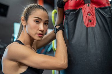 Egzersiz, sağlık, egzersiz ve konsept. Güzel Asyalı antrenör. Kas geliştiriyor, dambılları kaldırıyor ve aynaya bakıyor.