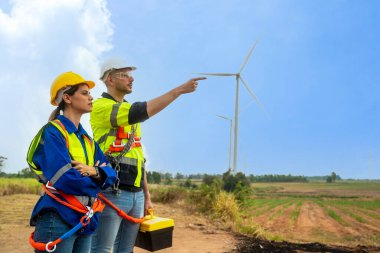 two engineers and a young man and a woman in a blue shirt and a white helmet and a wind