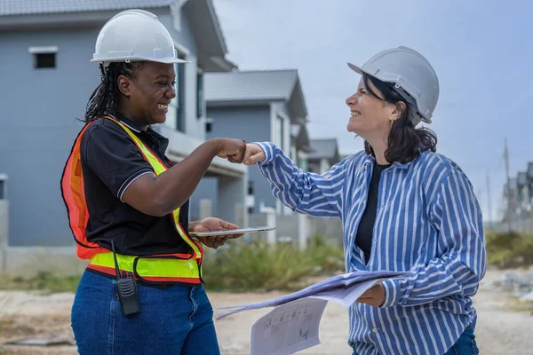 Construction work Concept.female architect, inspecting work with african american engineer talking, consulting together and serious work not finished to plan on housing construction project site .