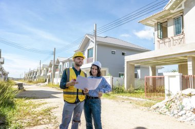 Mühendis ve mimar inşaat alanındaki planları tartışıyor