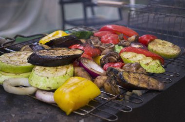 Izgara renkli sebze: dolmalık biber, kabak, açık gri kayrak üzerinde patlıcan, taş ya da beton arka plan. Kopyalama alanı olan üst görünüm.