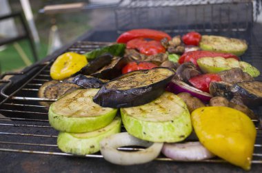 Izgara renkli sebze: dolmalık biber, kabak, açık gri kayrak üzerinde patlıcan, taş ya da beton arka plan. Kopyalama alanı olan üst görünüm.