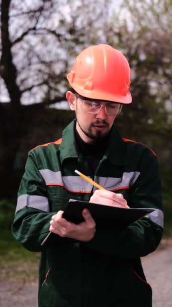 Ingenieur Een Beschermende Helm Maakt Vermeldingen Een Tijdschrift — Stockvideo
