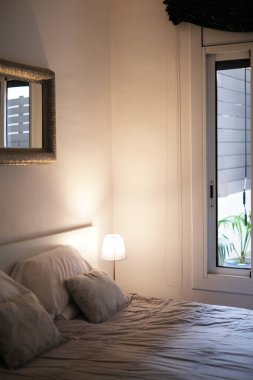 Yatak odasındaki komodinin üzerinde sıcak ışığın yumuşak lambası