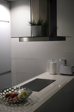 Kaputu ve elektrikli sobası olan modern stil mutfak adası.